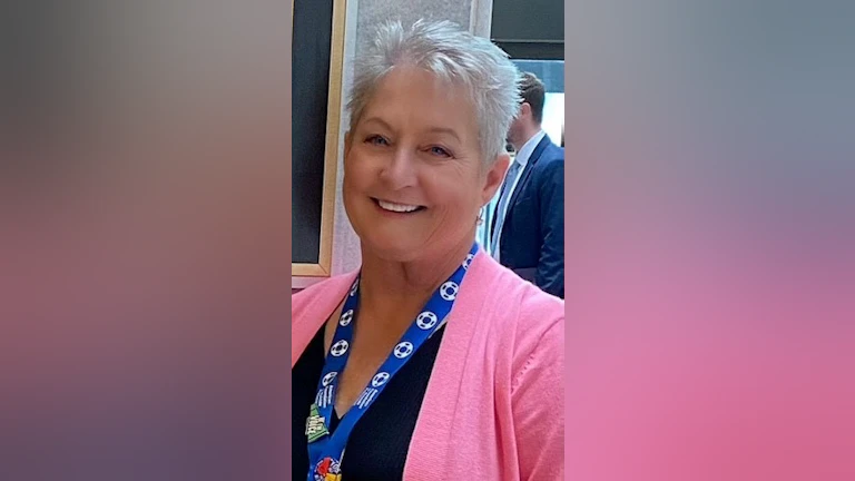 Candi Morris smiling and wearing a bright pink sweater.