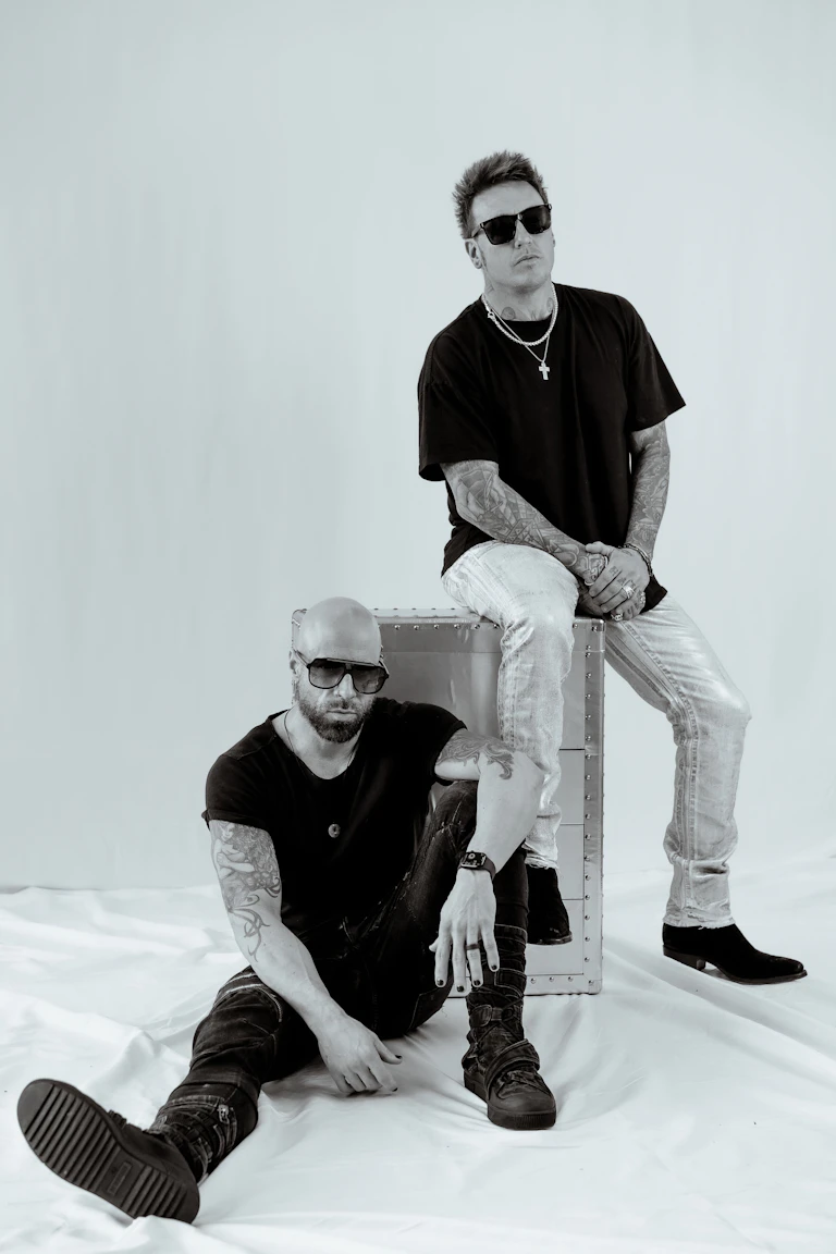 Musicians Chris Daughtry and Jacoby wear sunglasses and look at the camera
