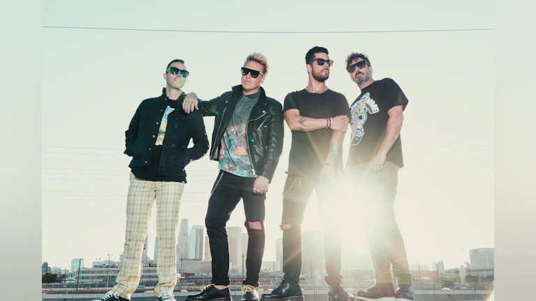 Papa roach band members pose in front of a sunrise