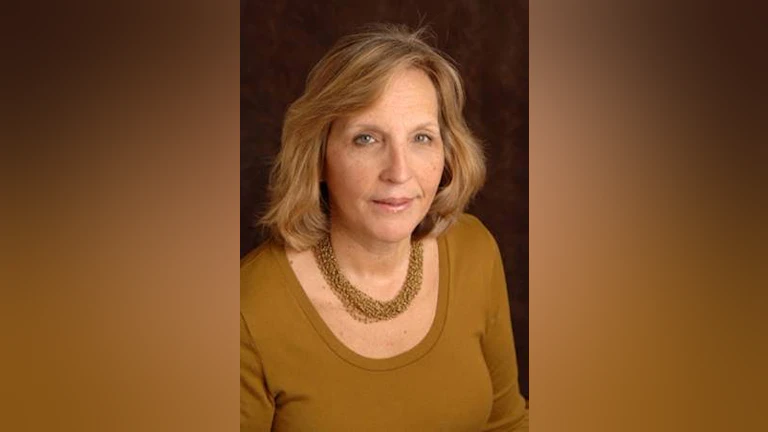 Dr. Barbara Stanley wearing an ochre top and matching ochre necklace