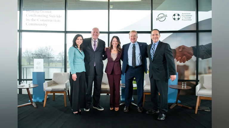 Bechtel and AFSP representatives smile on stage