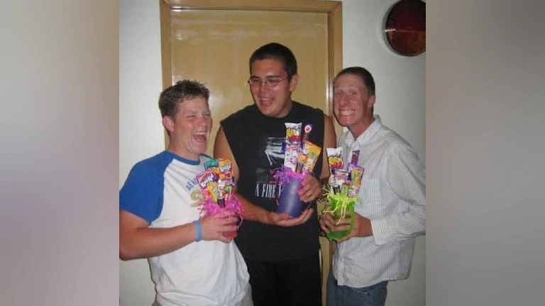 The author, Dennis Lasley, another childhood friend, and Sean Ferguson, all smiling and laughing. They're each holding a trophy they made for the soccer team they volunteered and coached for.