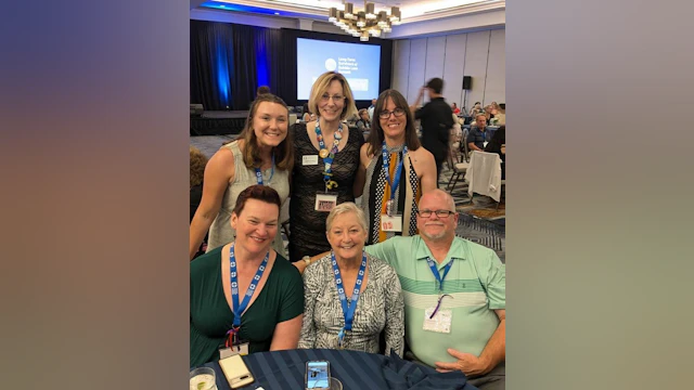 6 people smiling and posing for the camera
