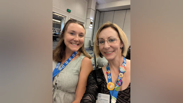 two people smiling and posing for the camera