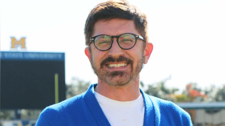 The author, Kevin Yaudes, smiling outdoors and wearing a blue sweater.