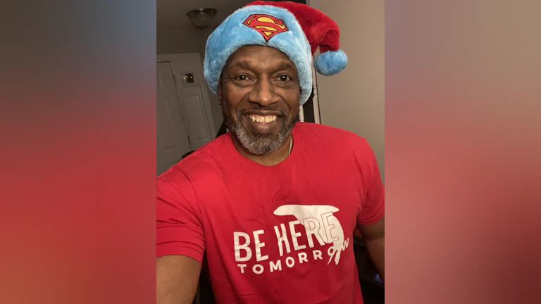 The author, Vic Armstrong, smiling and wearing a red t-shirt and Superman-themed Santa hat.