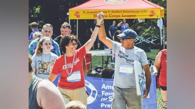 A couple holding their hands up and cheering at the end of the walk