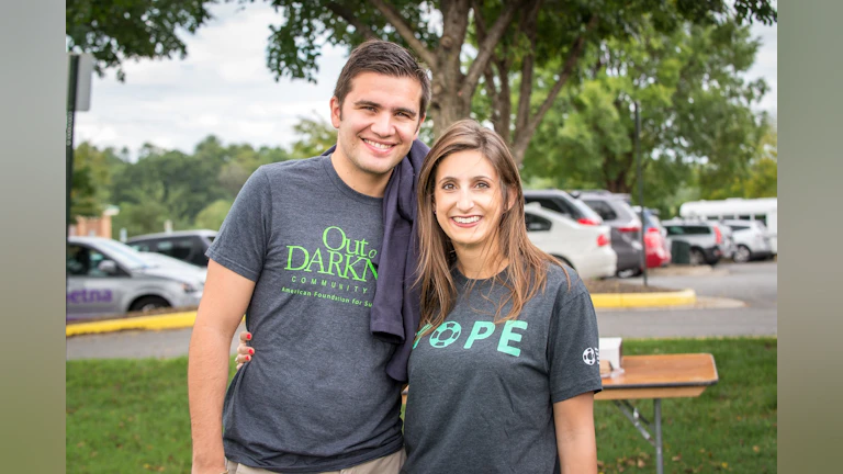 The author, Ali Walker, standing outside at an Out of the Darkness Walk event and wearing an AFSP "HOPE" t-shirt.