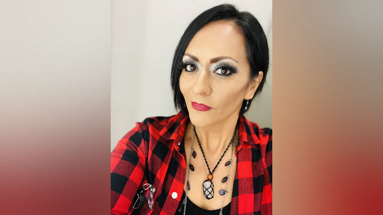 Ericka Llerena smiling for a headshot and wearing a red and black checked flannel.