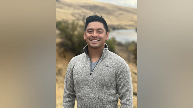 Vuong Tran standing outdoors and smiling.