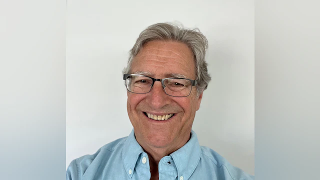 Dr. Rick Townsend smiling and wearing glasses and a light blue shirt.