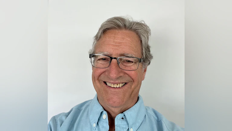 Dr. Rick Townsend smiling and wearing glasses and a light blue shirt.