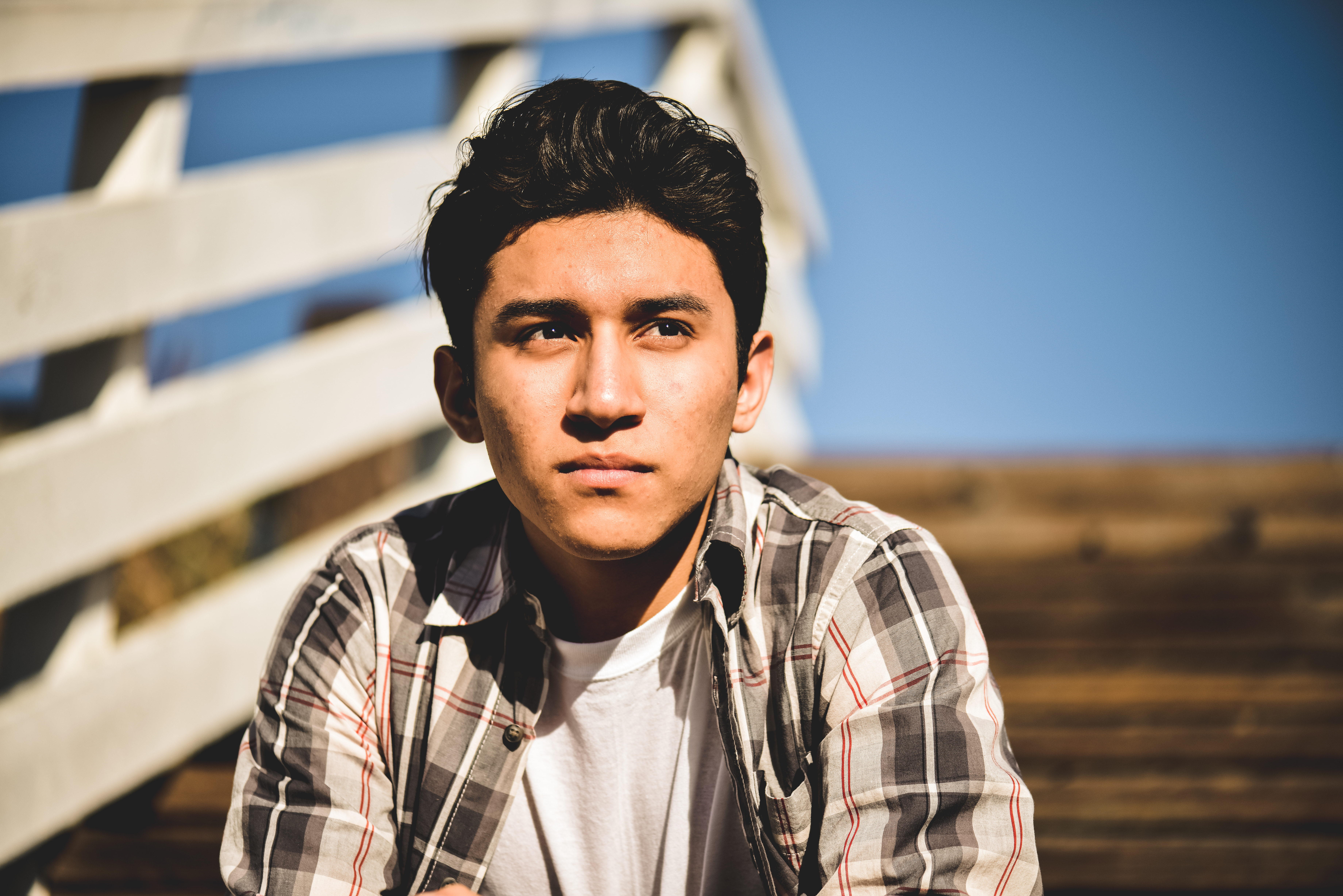 Lone young man sitting on a boardwalk