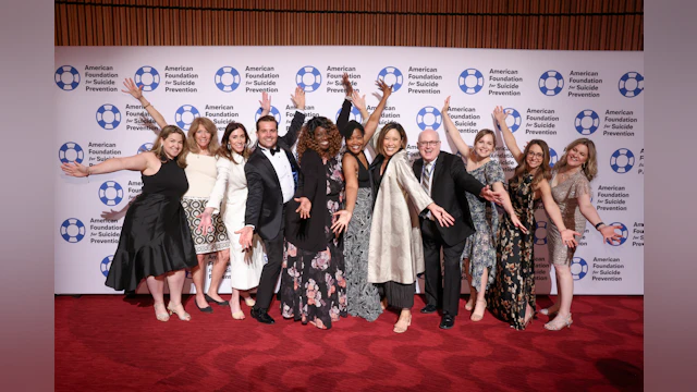 Cindy Hsu pictured with a group of people on the red carpet.