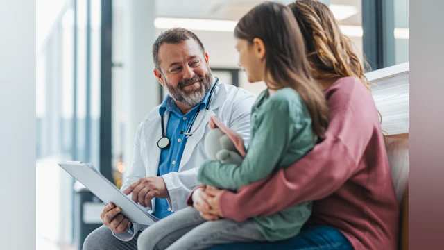 A physician sitting with two of his patients.