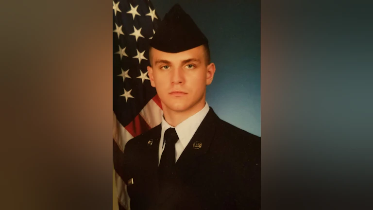 Karly Steinwehr's brother, Korbin Steinwehr, in uniform with an American flag in the background.