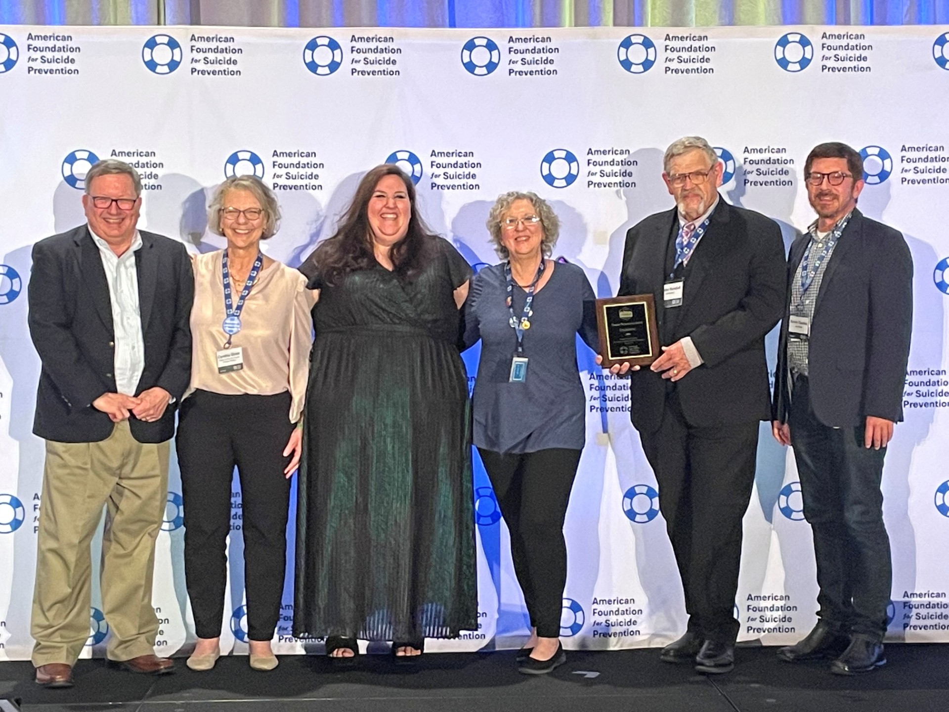 Bubba Randall, second to last on the right, pictured on a stage receiving an award from the American Foundation for Suicide Prevention.