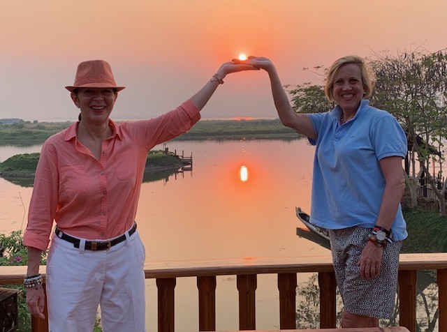 The author Ellen Marks (right) standing in front of a beautiful sunset with her late wife Monica Boll.