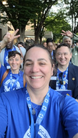 The author, Donna Birkholz, holding her camera and posing for a selfie with fellow Volunteer Advocates at the 2025 Advocacy Forum.