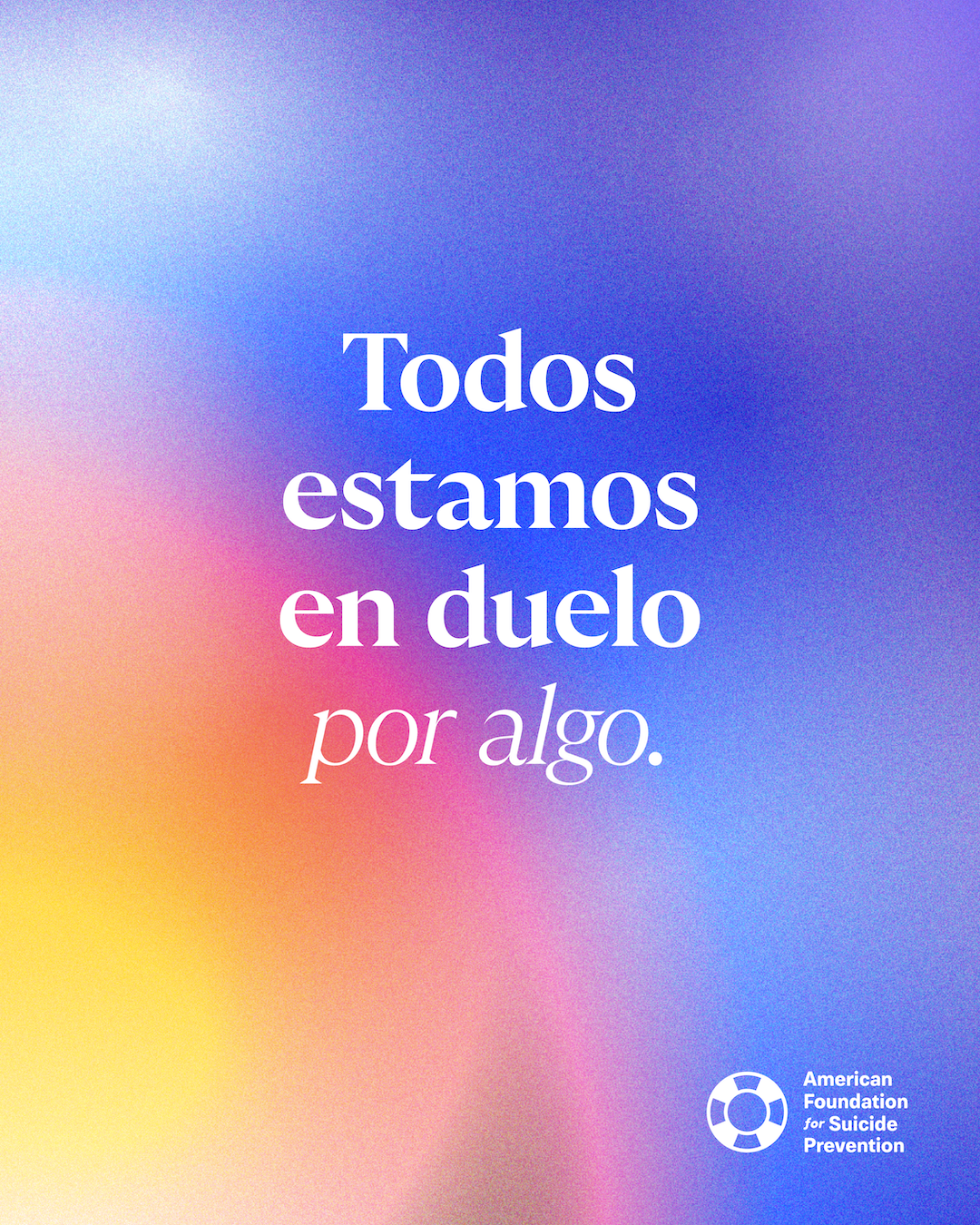 Spanish-language graphic reading “Todos estamos en duelo por algo” (We are all grieving something). White serif lettering over a soft blurred gradient of blue, pink, orange and yellow, with the American Foundation for Suicide Prevention logo.