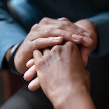 Close up of young couple hold hands talking sharing secrets showing love and care, husband and wife have tender close moment together, demonstrate support and understanding