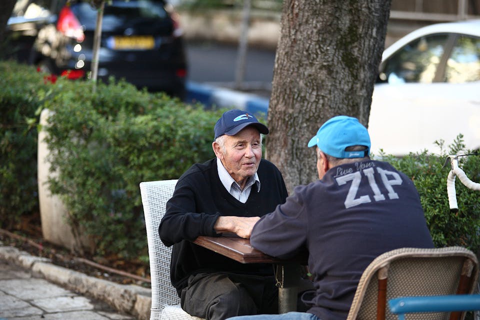 Two men talking at the Butke Cafe in Jerusalem in 2014. *Dan Porges/Getty Images*. Philologos Emphasis Main