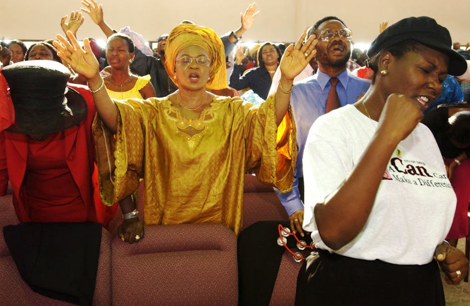 LAGOS, NIGERIA – SEPTEMBER 28: Nigerian Christians pray together at the City of David Church September 28, 2003 in the affluent Victoria Island section of Lagos, Nigeria. Evangelical and Pentecostal churches in Nigeria are not only the domain of the nation’s poor, but also of its very wealthy. Evangelical and Pentecostal Christianity are spreading in many parts of the developing world, often outgrowing traditional forms of Christianity first brought by colonizers and long dominant. (Photo by Jacob Silberberg/Getty Images)
