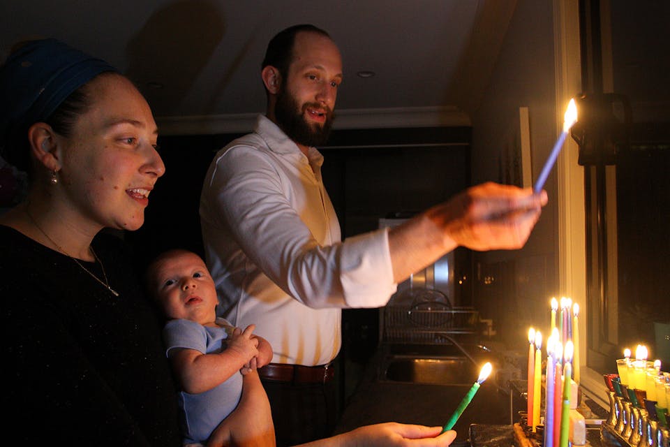 A family light their menorah at home on December 15, 2020 in Sydney, Australia. *Lisa Maree Williams/Getty Images*. Maoz Tsur Main