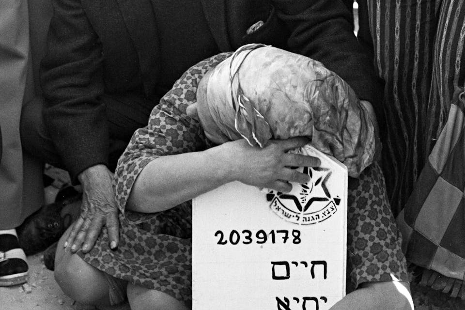 A bereaved mother hugs the tombstone of her son, who died in the Yom Kippur War in 1973. *David Rubinger/CORBIS/Corbis via Getty Images.* Wisse Ozick Main