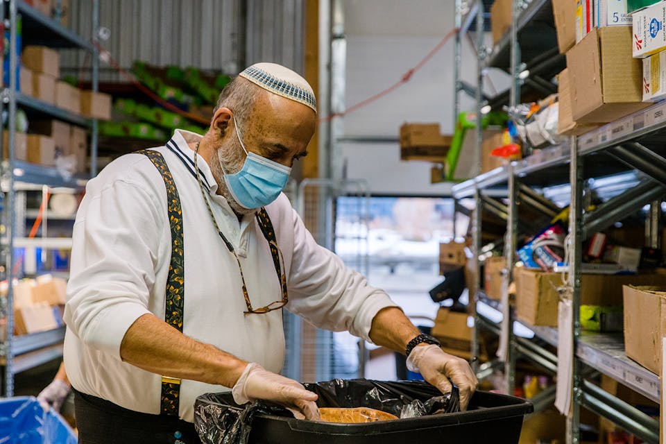 A volunteer prepares meals at Chasdei Kaduri Jewish Food Bank in Toronto in November 2020. *Shawn Goldberg/SOPA Images/LightRocket via Getty Images.* Wertheimer Donors Main