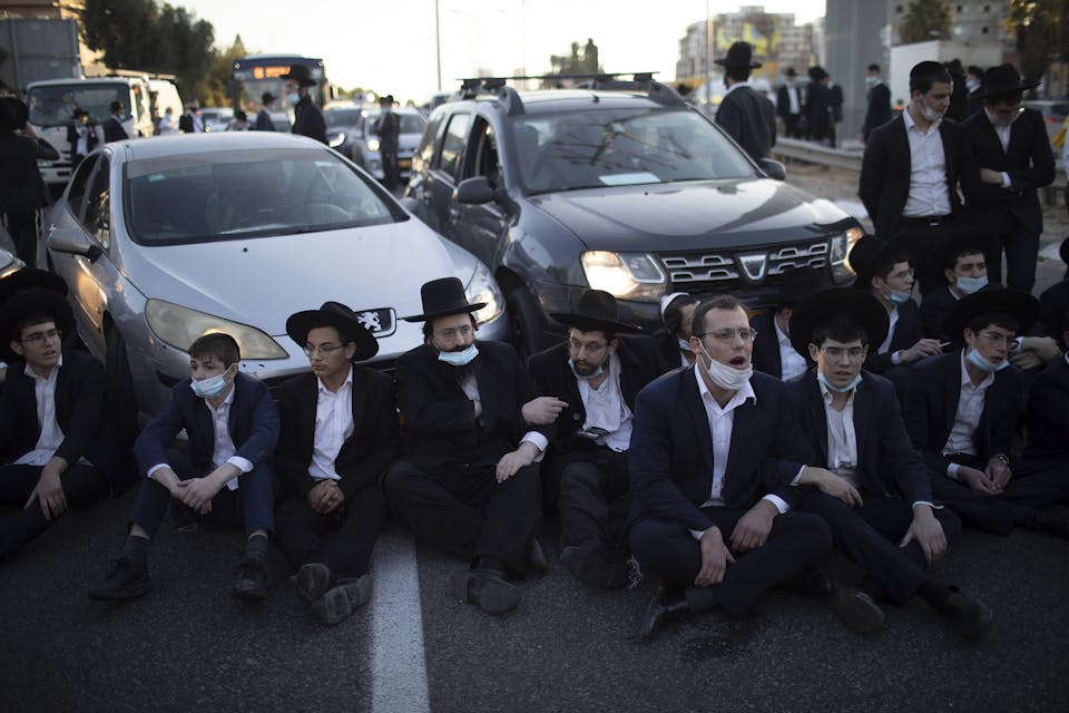 27 December 2020, Israel, Bnei Brak: Ultra-Orthodox Jews block a road during a demonstration staged moments before Israel enters its third nationwide lockdown amid the coronavirus pandemic. Photo: Ilia Yefimovich/dpa (Photo by Ilia Yefimovich/picture alliance via Getty Images)