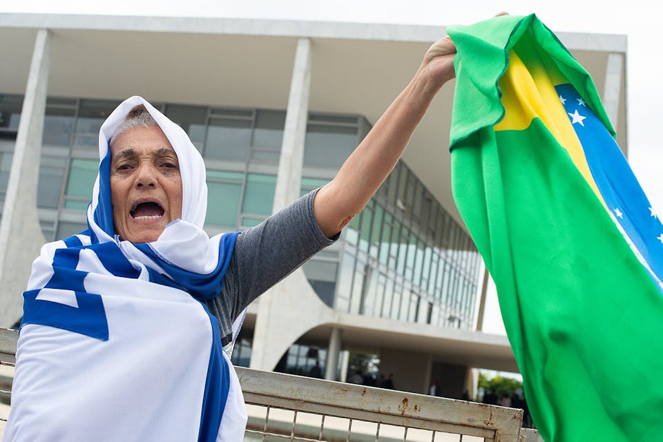 A Brazilian woman wrapped in Israel's flag while holding the Brazilian flag in her hand on May 7, 2020 in Brasilia. *Andressa Anholete/Getty Images*. Brazil Main