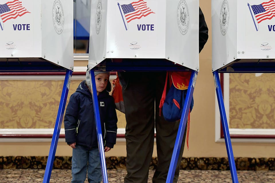 A voter casts his ballot with his child at the East Midwood Jewish Center polling station in Brooklyn on November 6, 2018. *ANGELA WEISS/AFP via Getty Images.* Voting Main
