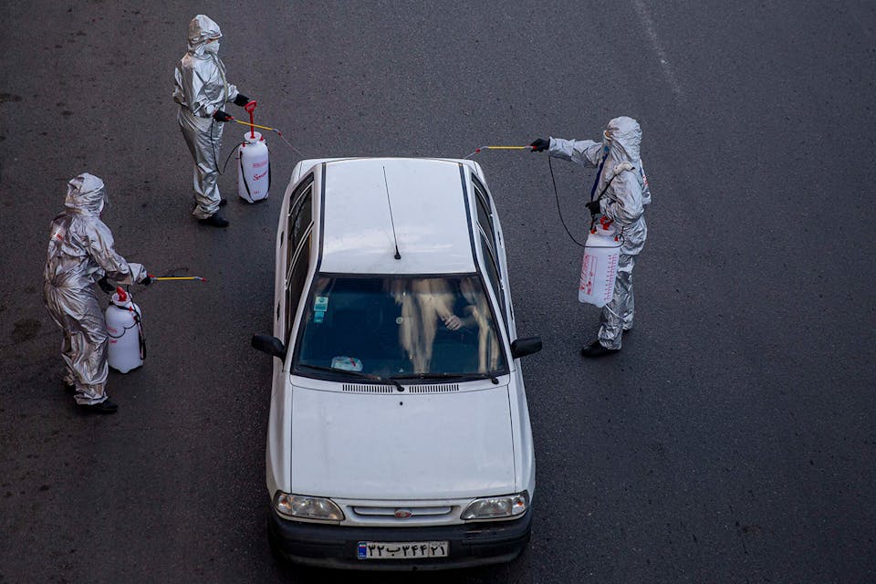 *Volunteers spraying disinfectant on a car during the coronavirus pandemic on March 31, 2020 in Tehran.* Majid Saeedi/Getty Images. Iran Corona Main
