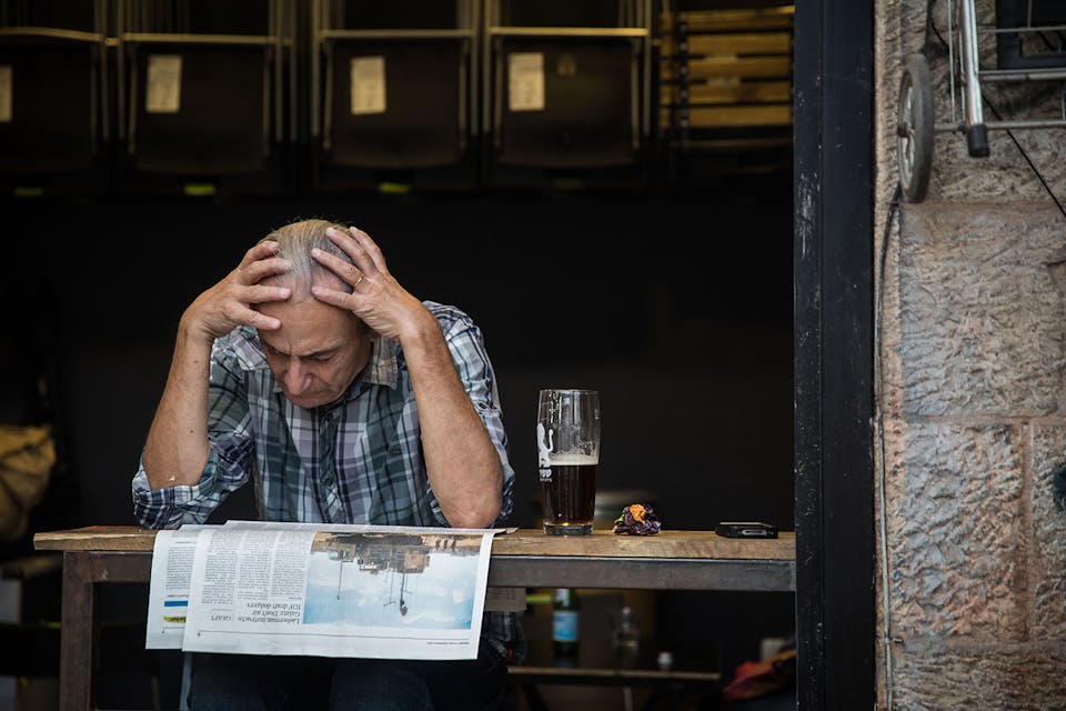 *A man reads the newspaper at a cafe at the Mahane Yehuda Market in Jerusalem on September 5, 2017.* Hadas Parush/Flash90. Two Languages Main