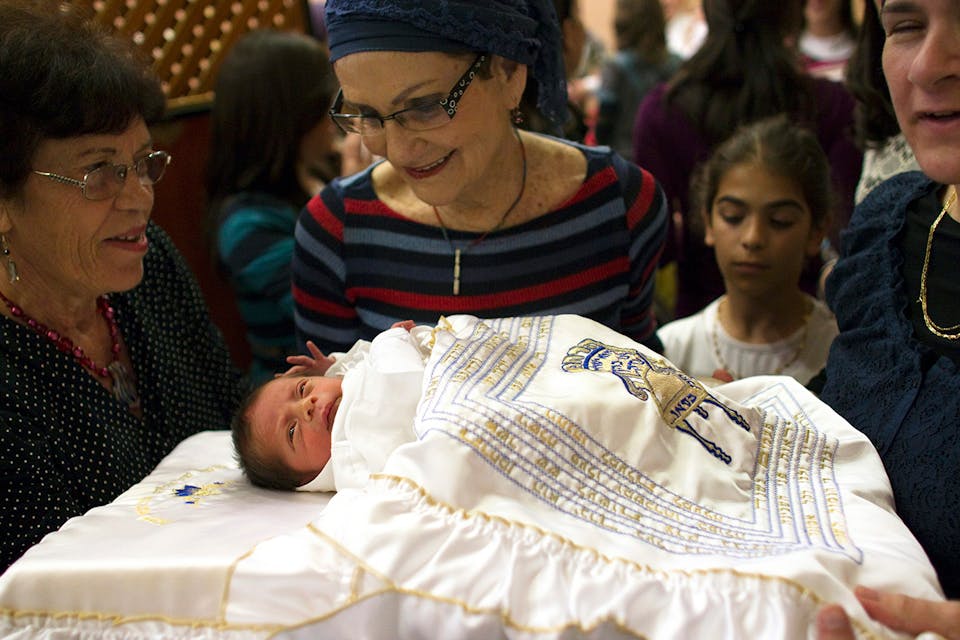 *A baby and relatives after his circumcision.* REUTERS/Ronen Zvulun. Circ