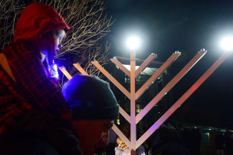 *A child on his father's shoulders on the first night of Hanukkah.* Brent Lewis/The Denver Post via Getty Images. Hanukkah Main