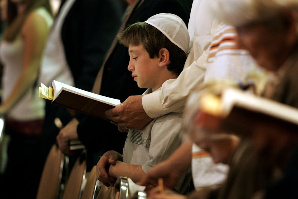 *A father and son praying.* Gina Ferazzi/Los Angeles Times via Getty Images. Adon Olam