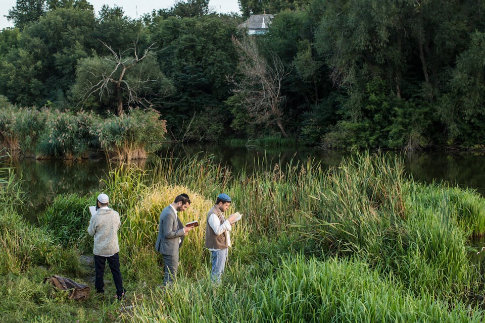 *Hasidic pilgrims pray along a river near the burial site of Rabbi Nachman of Breslov in Uman, Ukraine.* Brendan Hoffman/Getty Images. Uman