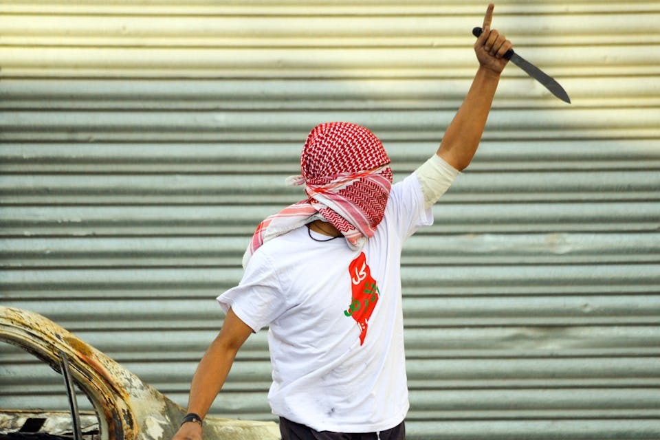 *A Palestinian demonstrator raises a knife during clashes with Israeli police in the Shuafat refugee camp in Jerusalem, Friday, Oct. 9, 2015.* AP Photo/Mahmoud Illean. Knife-Intifada-Main