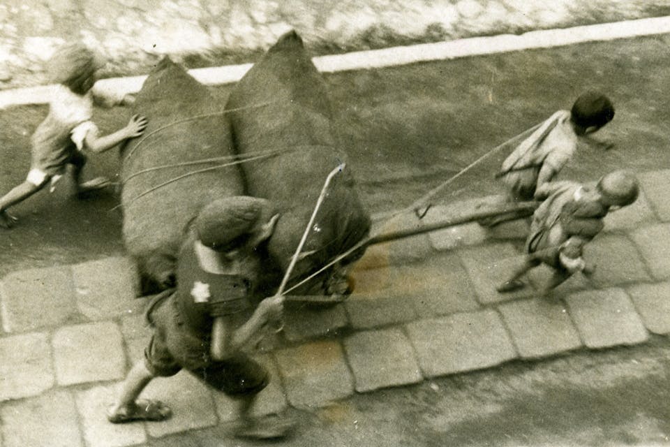Jewish children pulling a cart with two bags in the Łódź ghetto. travailler09