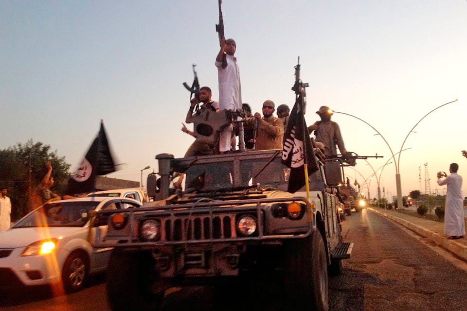 *Islamic State fighters parade in a commandeered Iraqi armored vehicle in Mosul in 2014.* AP. Doran-ME-Main