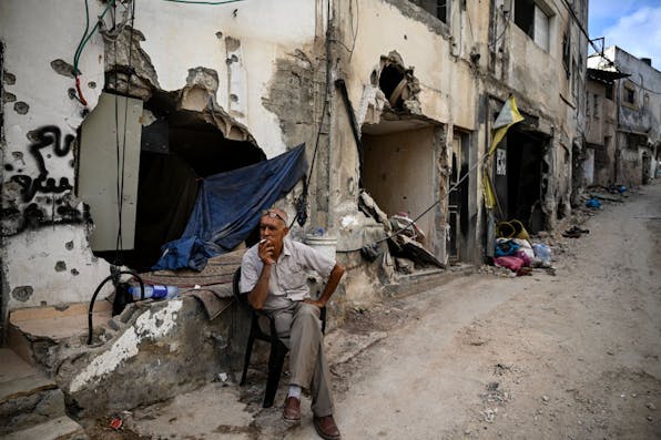 TOPSHOT – A man sits in front of a damaged building following an Israeli military raid in the Jenin refugee camp, in the occupied West Bank on September 6, 2024. Israeli forces withdrew from Jenin in the occupied West Bank on September 6 after a deadly 10-day operation, witnesses said, as Hamas blamed Israel for deadlock in Gaza truce talks. (Photo by RONALDO SCHEMIDT / AFP) (Photo by RONALDO SCHEMIDT/AFP via Getty Images)