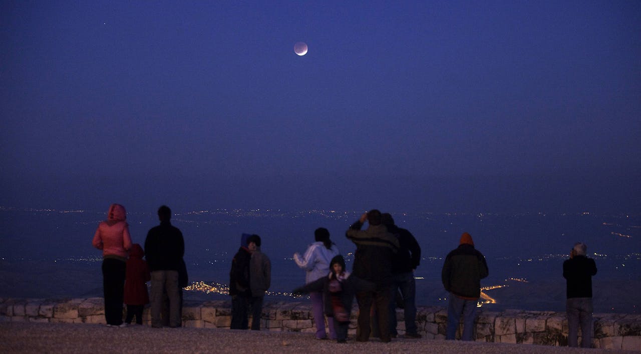 Israelis looks at a full lunar eclipse above the Judean desert from Jerusalem's Mount Scopus on December 10, 2011. *MENAHEM KAHANA/AFP via Getty Images*. Herman Space
