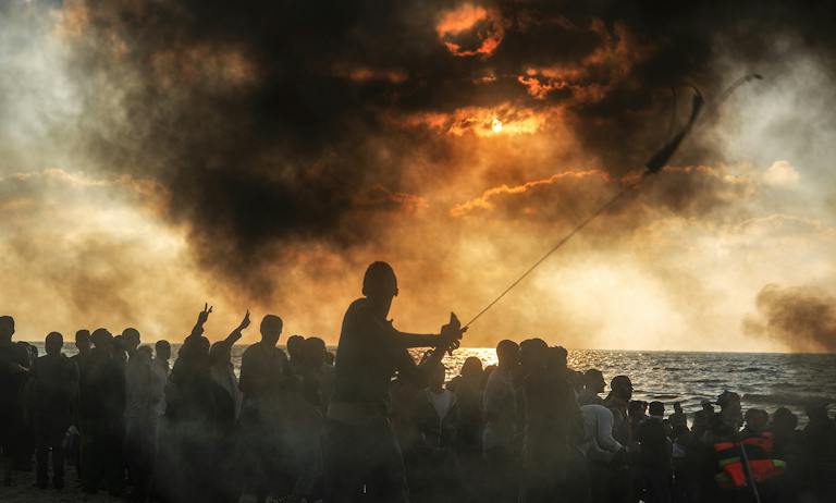 Palestinians gathering to support a 20-vessel flotilla that set out in hopes of breaking the Israeli blockade of the Gaza Strip in September 2018. *Ali Jadallah/Anadolu Agency/Getty Images*. Mor Gaza Essay Main