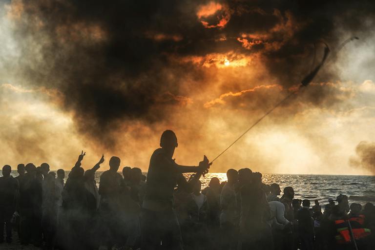 Palestinians gathering to support a 20-vessel flotilla that set out in hopes of breaking the Israeli blockade of the Gaza Strip in September 2018. *Ali Jadallah/Anadolu Agency/Getty Images*. Mor Gaza Essay Main
