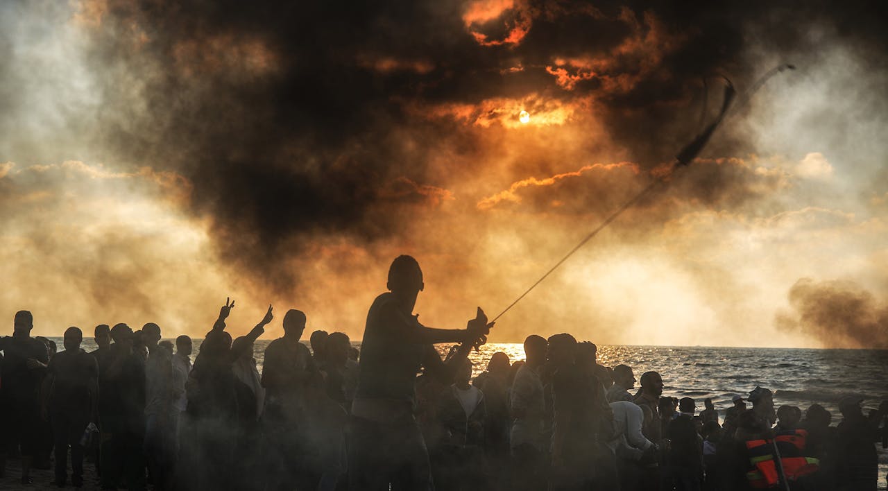 Palestinians gathering to support a 20-vessel flotilla that set out in hopes of breaking the Israeli blockade of the Gaza Strip in September 2018. *Ali Jadallah/Anadolu Agency/Getty Images*. Mor Gaza Essay Main