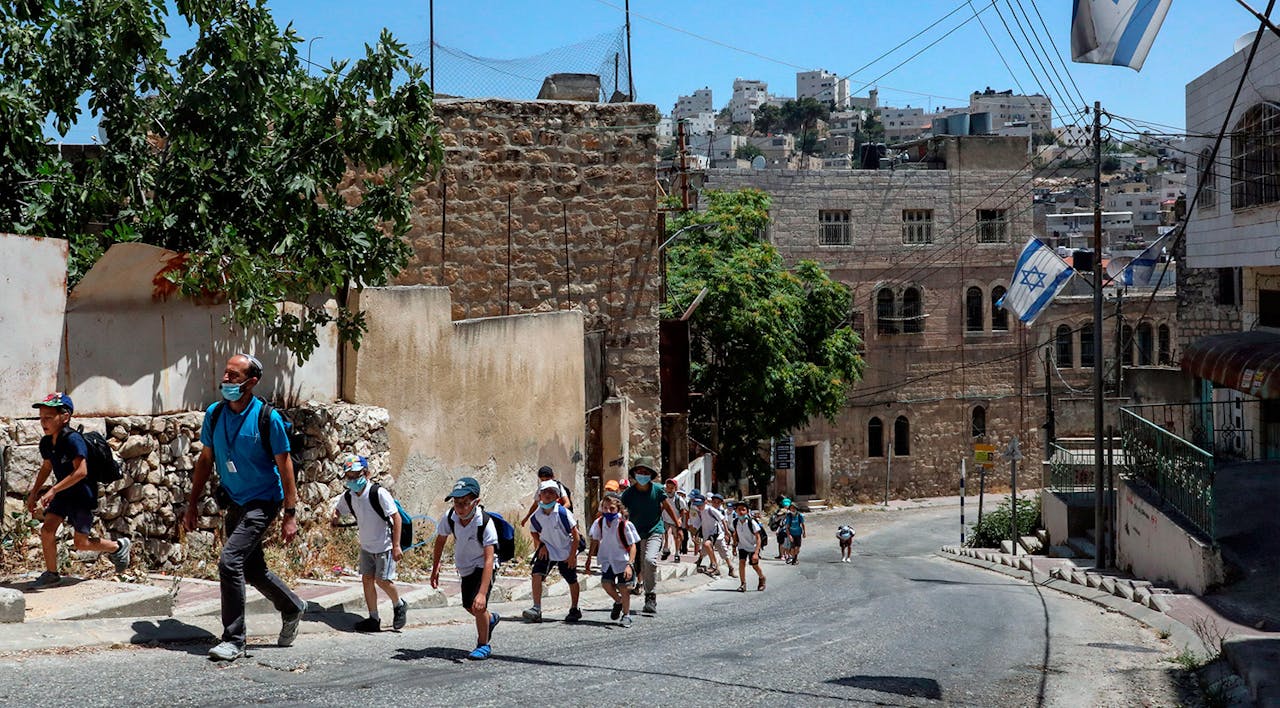 Israeli settlers with children walk in the city of Hebron on June 30, 2020. *HAZEM BADER/AFP via Getty Images*. Kane Main
