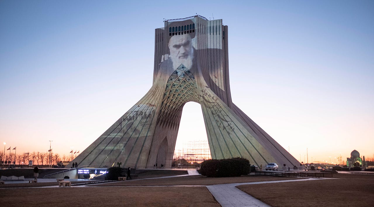 A portrait of the late Ayatollah Khomeini projected on the Azadi (Freedom) Monument in western Tehran on the 43rd anniversary of Iran's 1979 Islamic Revolution in February 2022. *Morteza Nikoubazl/NurPhoto via Getty Images*. Maghen Iran Main