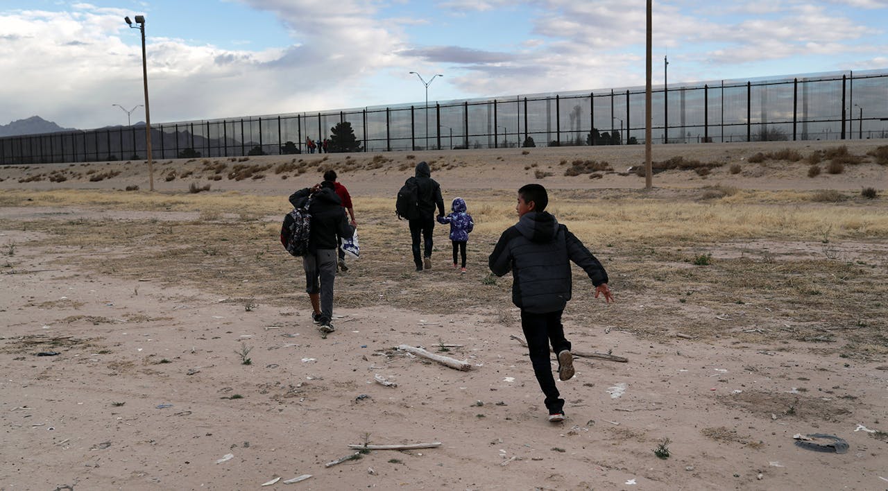 *Central American immigrants walk toward **the border fence after crossing the Rio Grande from Mexico on February 1, 2019 in El Paso, Texas.* John Moore/Getty Images. Immigration Gallagher Main